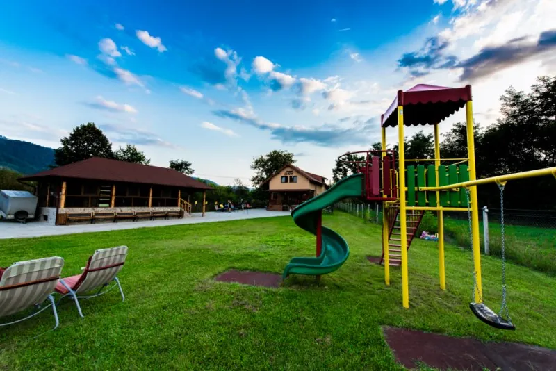 The guesthouse garden with its playground, enclosed wooden pavilion and main house